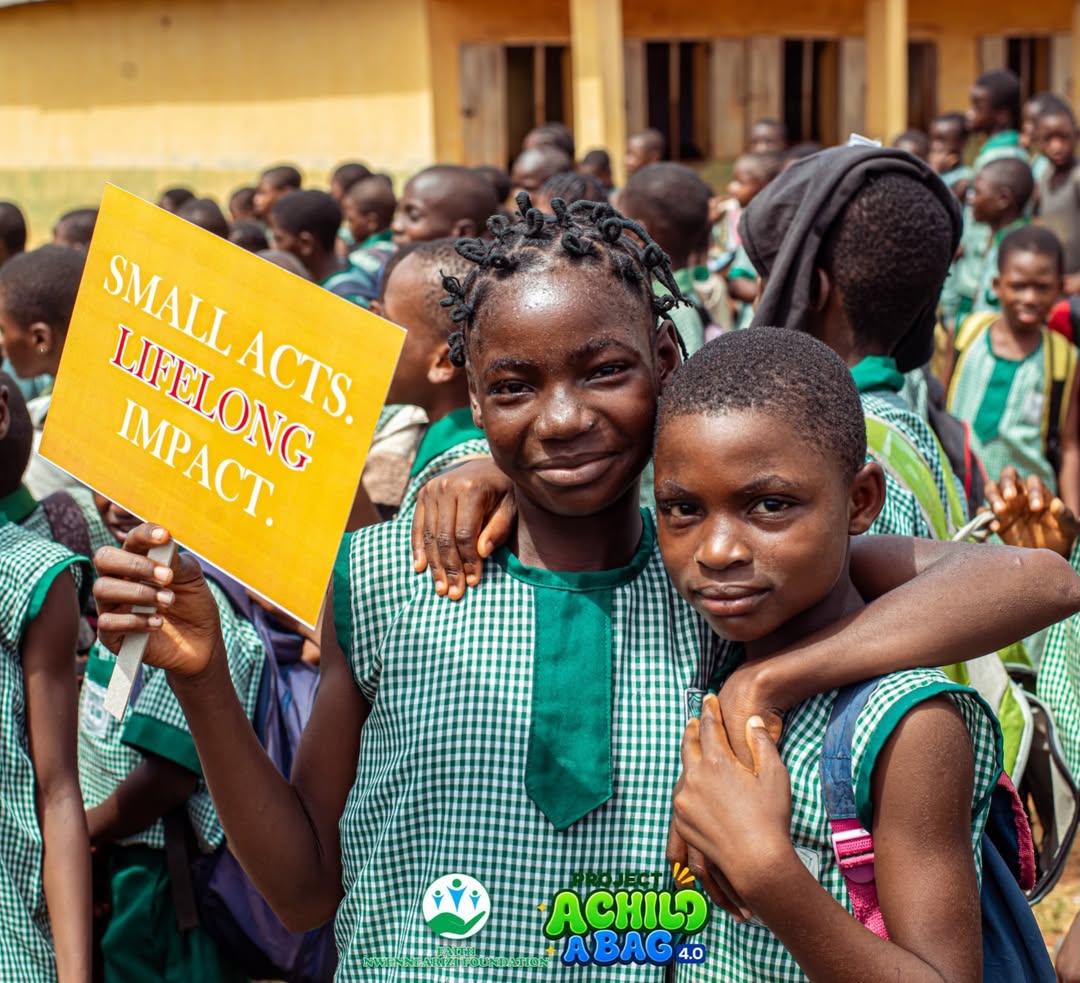 Pupils holding 'Small Acts. Lifelong Impact.' sign